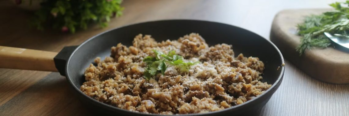 Tasty minced meat dish garnished with herbs in a black skillet, perfect for a delicious homemade meal.